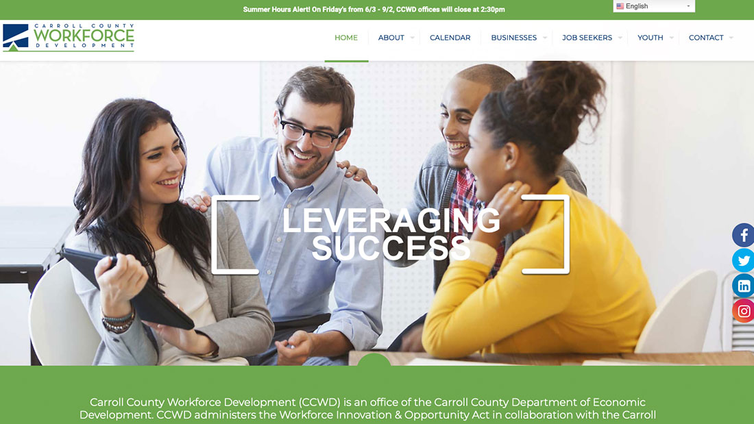 Four diverse professionals smiling and discussing around a tablet.