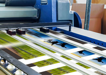 A close-up of a high-speed digital printing press in operation, illustrating printing capabilities.